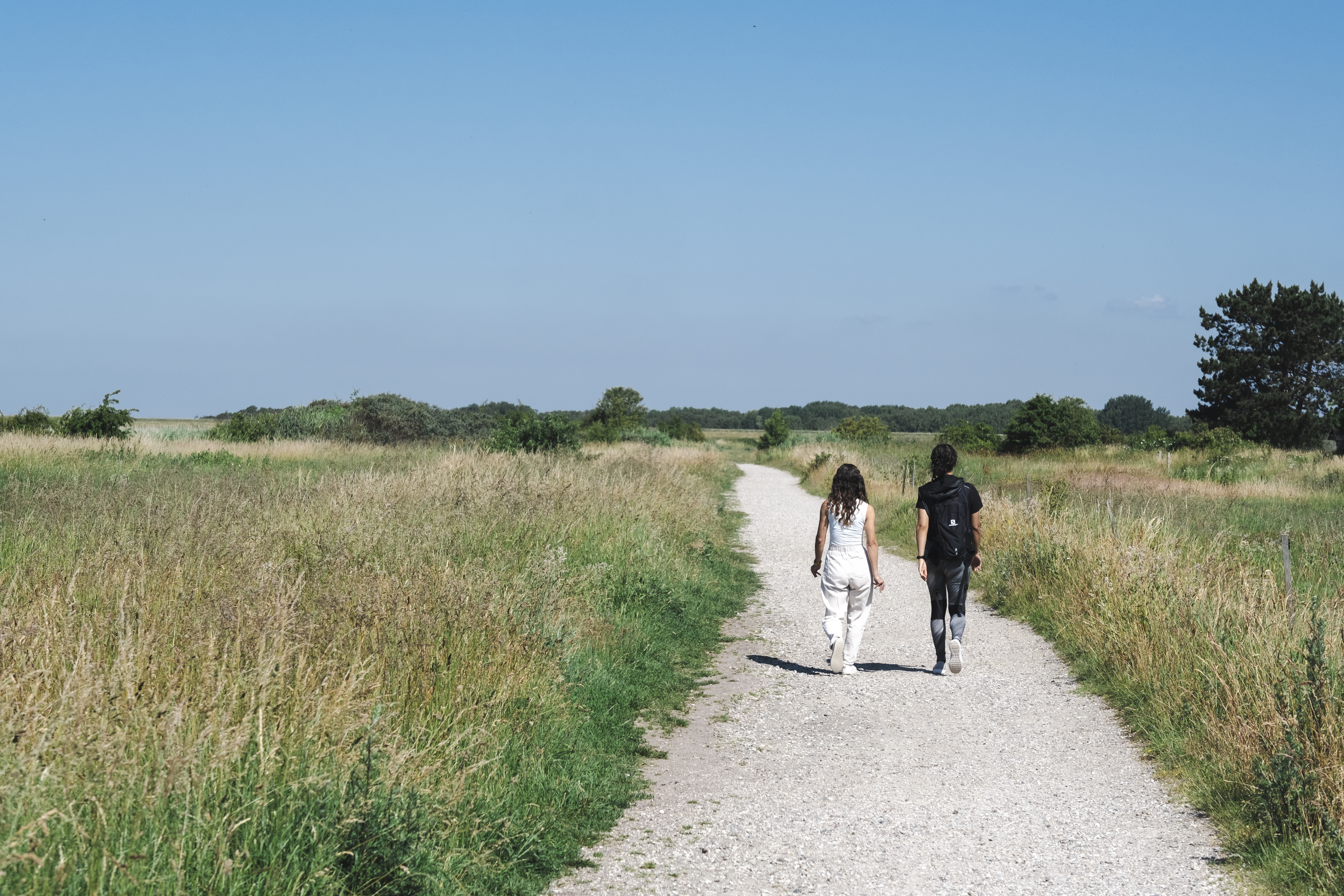 To kvinder går på en sti i det åbne landskab