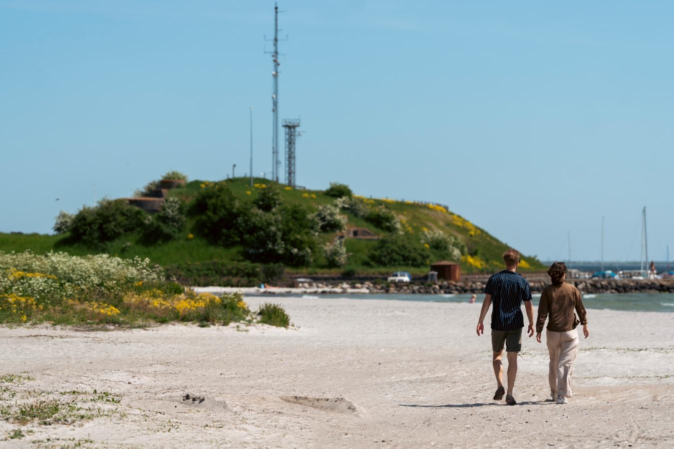To personer går på strand